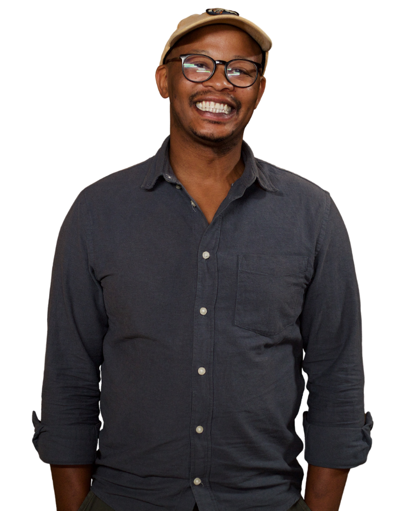 Banele Vakele in a cap and glasses smiles.
