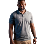 Man in gray Umbro polo and khaki shorts smiling