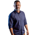 Andri Hanekom om a down shirt and tan pants, looking at camera