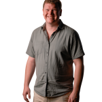 Andrew Mellish in a gray short-sleeved shirt and khaki shorts